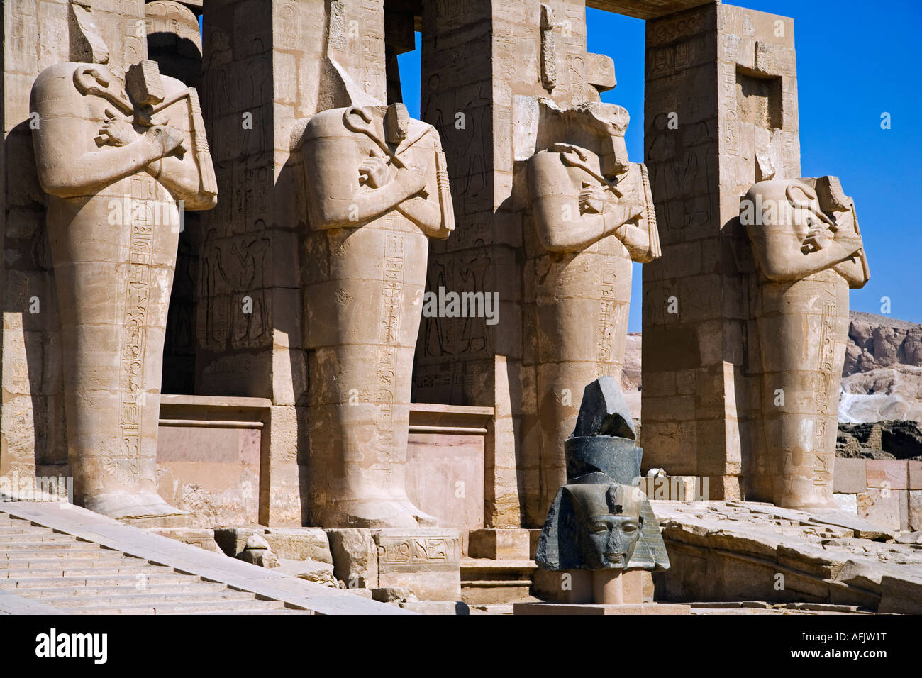 Headless statues de Ramsès II line la cour à l'entrée du Ramesseum, Louxor. Banque D'Images