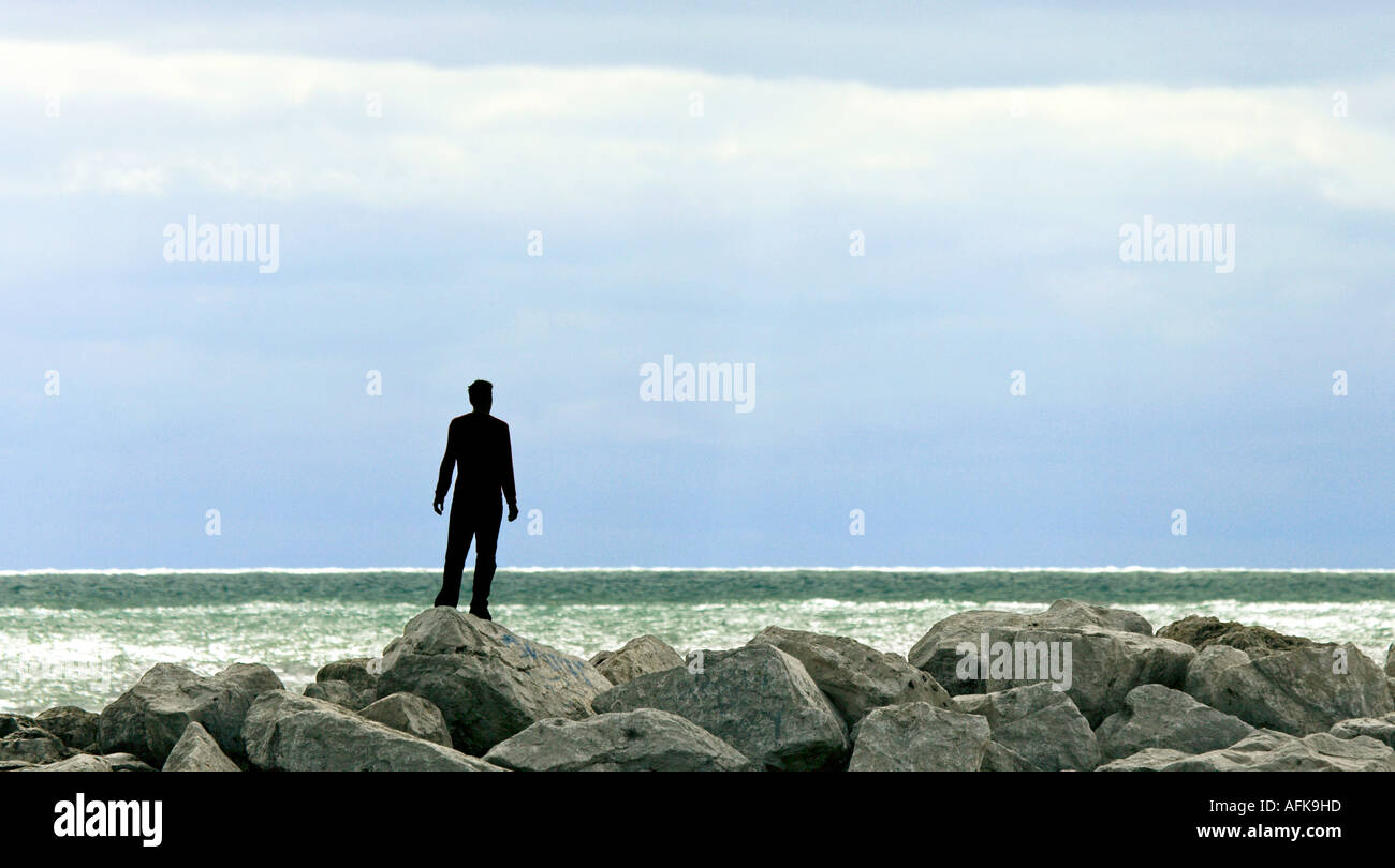 Silhouette de jeune homme debout sur des rochers au bord du Lac Michigan Banque D'Images
