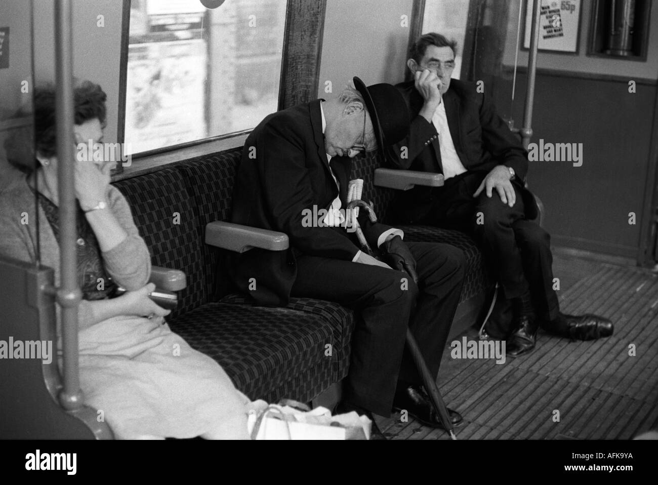 Homme d'affaires fatigué endormi de Londres dans le chapeau melon sur le train de métro de Londres rentrant à la maison après le travail Angleterre années 1970 HOMER SYKES Banque D'Images