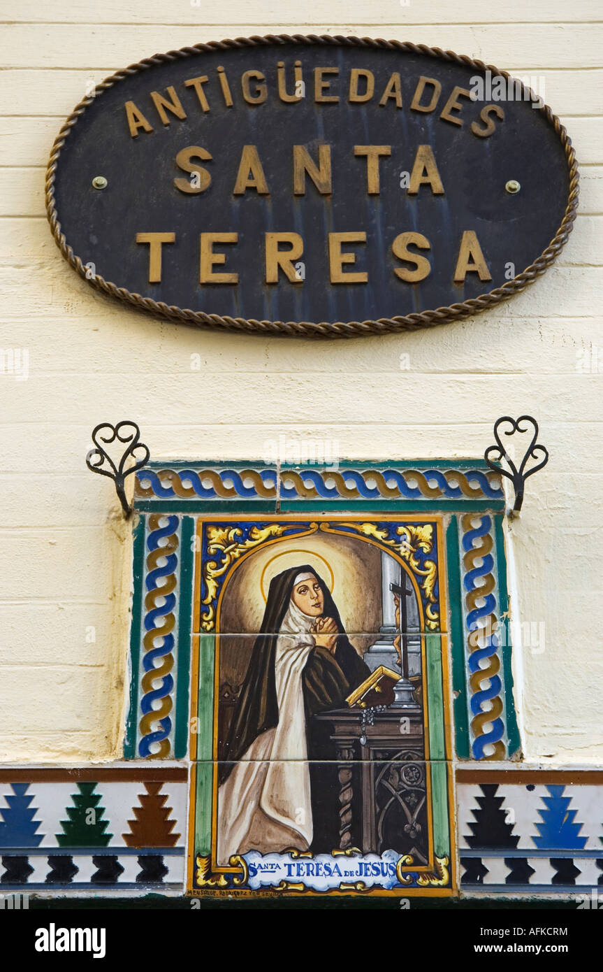 Une céramique peint peinture murale représentant Santa Teresa prier devant une croix, sur un mur à Séville, Espagne Banque D'Images