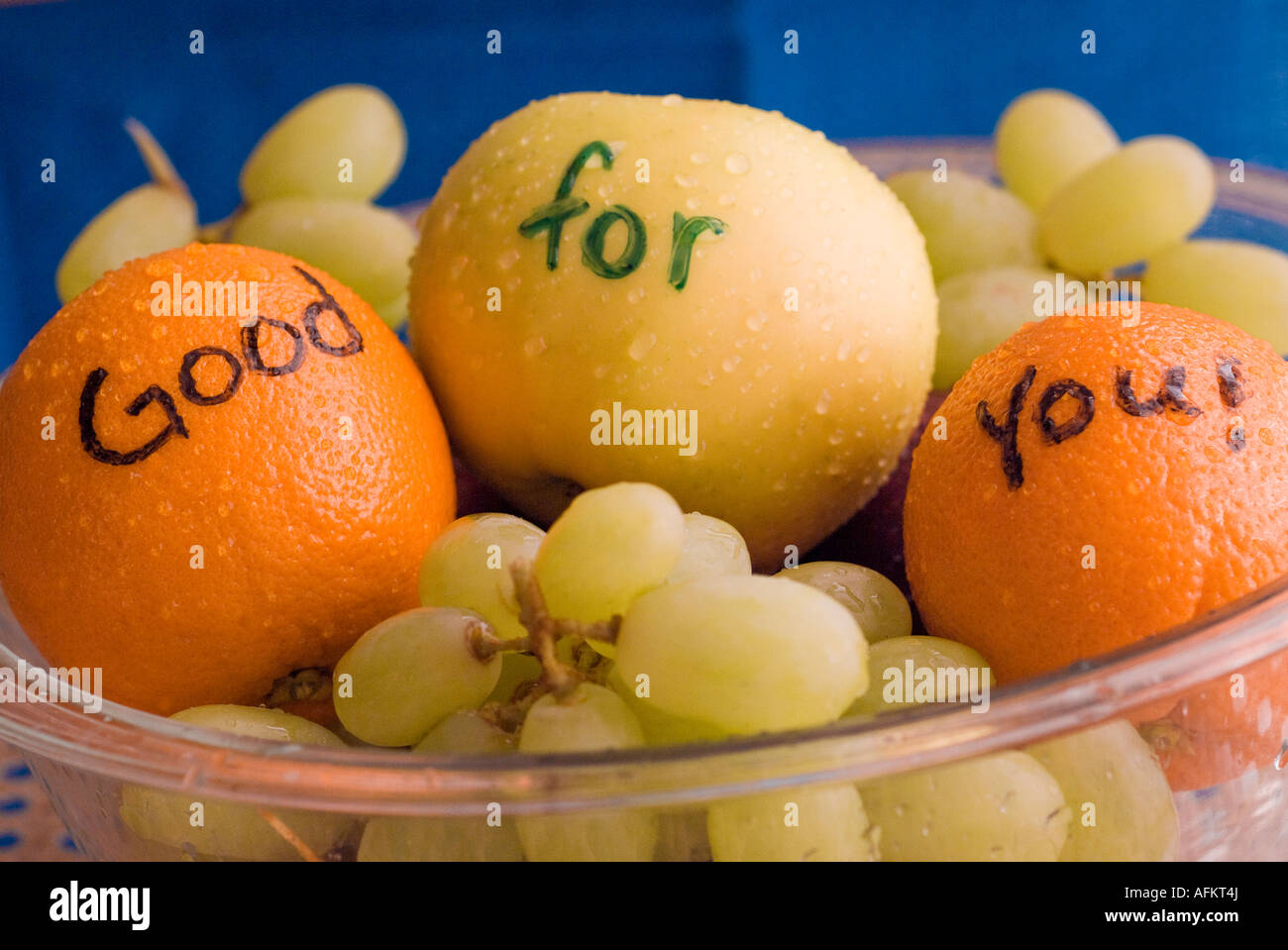 Bol de fruits plein d'oranges pommes raisins Banque D'Images