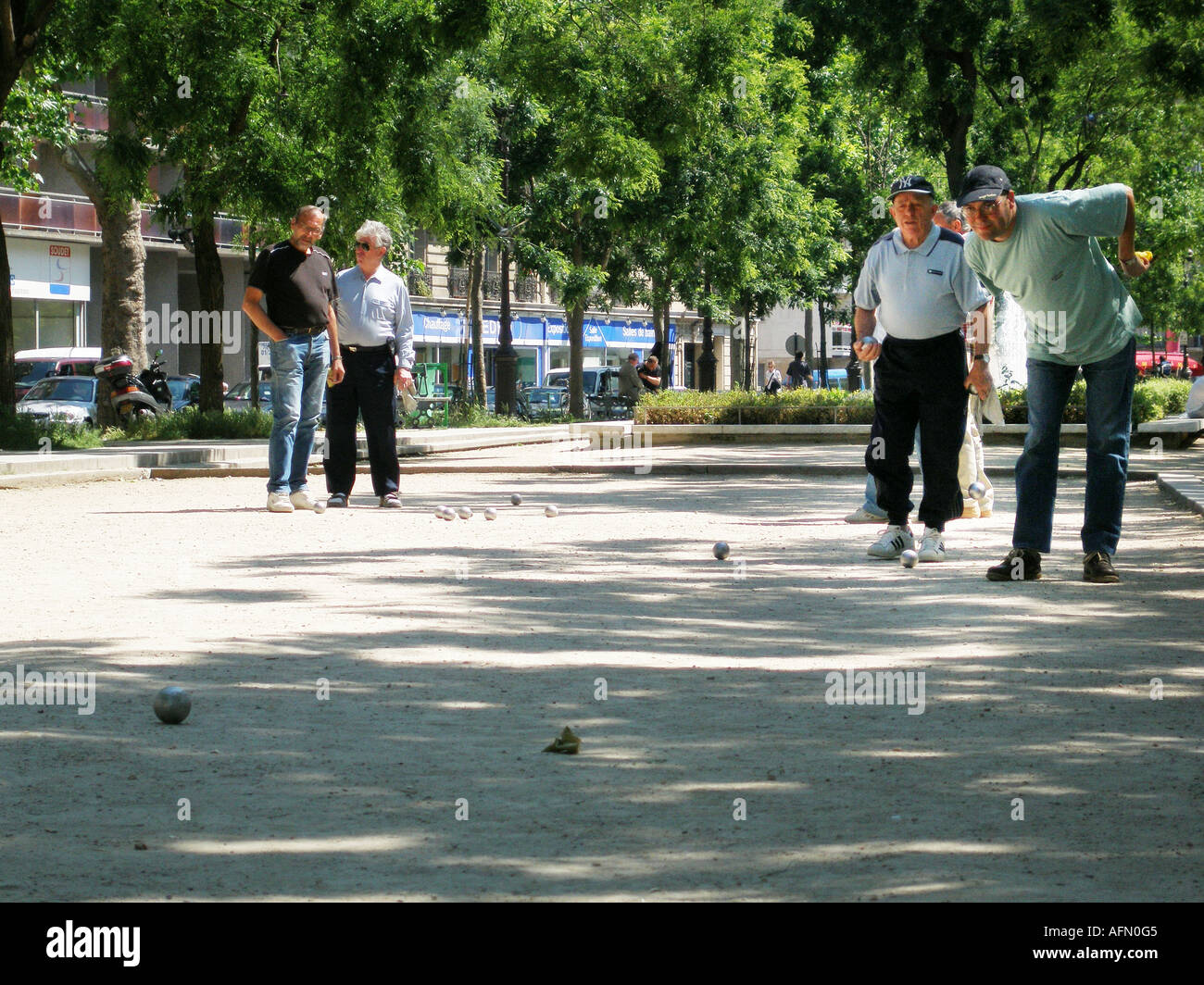 Groupe d'hommes d'âge moyen de jouer à un jeu de pétanque dans le parc parisien Paris France Banque D'Images