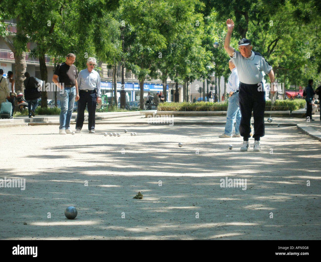 Groupe d'hommes d'âge moyen de jouer à un jeu de pétanque dans le parc parisien Paris France Banque D'Images