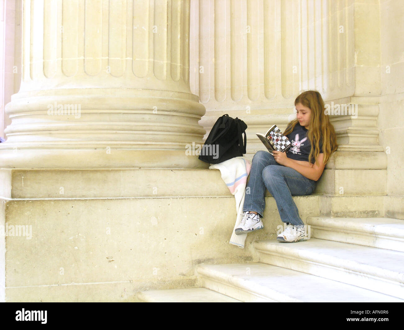Teenage girl sitting contre un pilier de la lecture à l'intérieur du dôme des Invalides Paris France Banque D'Images
