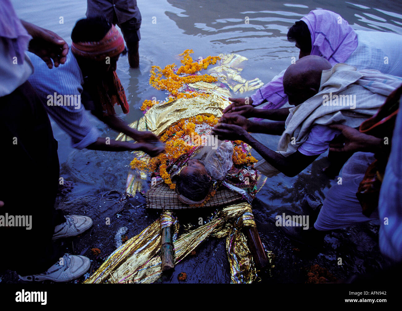 L'Inde Uttar Pradesh Varanasi l'un des derniers avant le corps cremating rite est l'eau offrant le corps est deeped dans le Gange pour la dernière fois en tant que la purification finale de l'offre famille de l'eau pour leur relative lui donnant l'eau symbolique pour le long voyage son âme s'apprête à prendre Banque D'Images