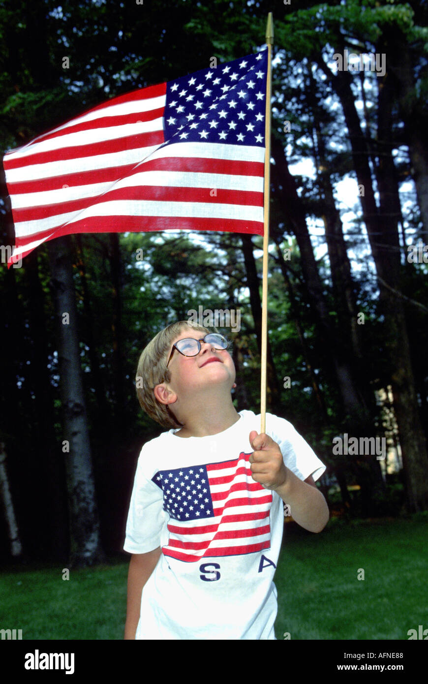 Garçon tient le drapeau américain à un pique-nique du 4 juillet Banque D'Images