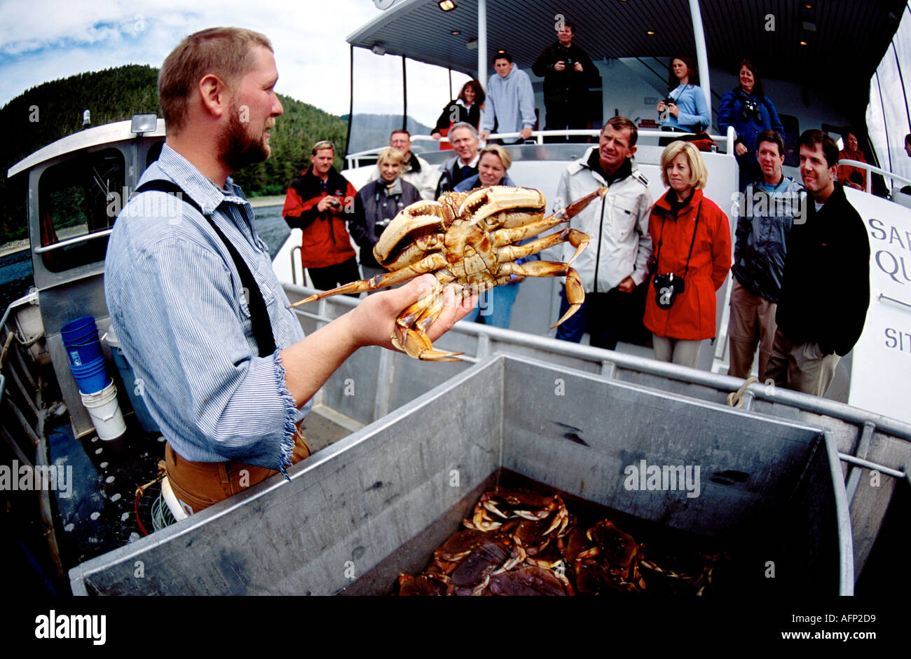 USA Alaska Commercial pêcheur de crabe montrant ses prises à des gens sur un bateau de croisière au large du sud-est de l'Alaska Banque D'Images