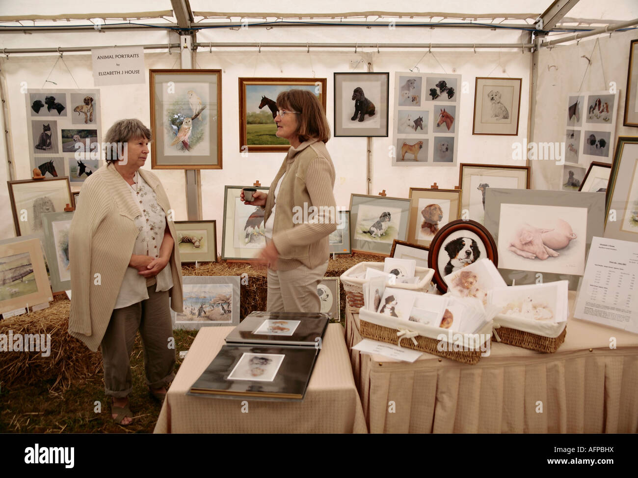 Artiste de portrait d'animal parlant à une cliente à son stand à Craft Fair, Angleterre, Royaume-Uni Banque D'Images
