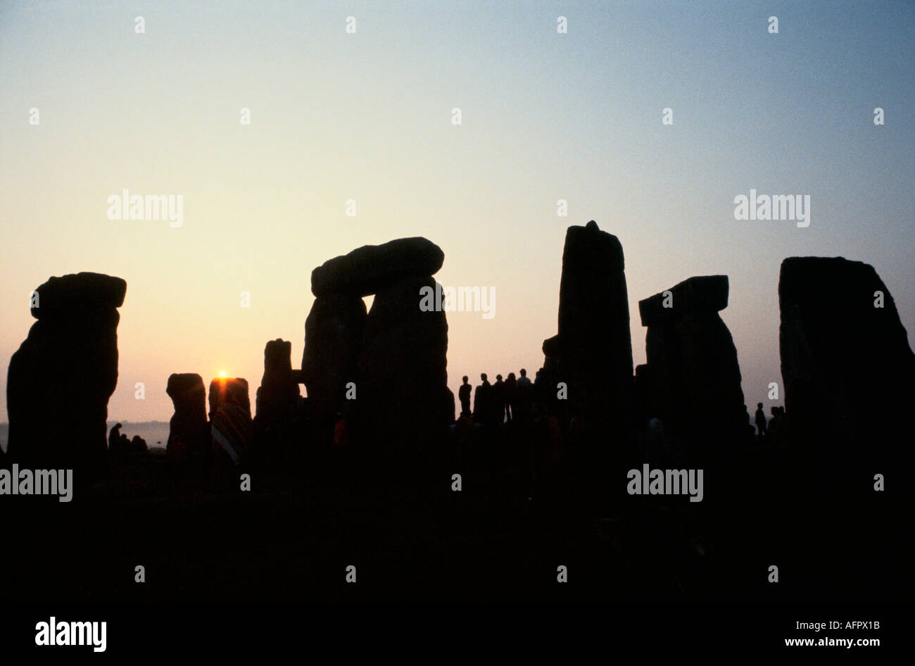 Stonehenge Dawn, les gens silhouettés se sont rassemblés pour le solstice d'été Royaume-Uni. Ils regardent le lever du soleil. 21 juin Angleterre Royaume-Uni des années 1970 HOMER SYKES Banque D'Images