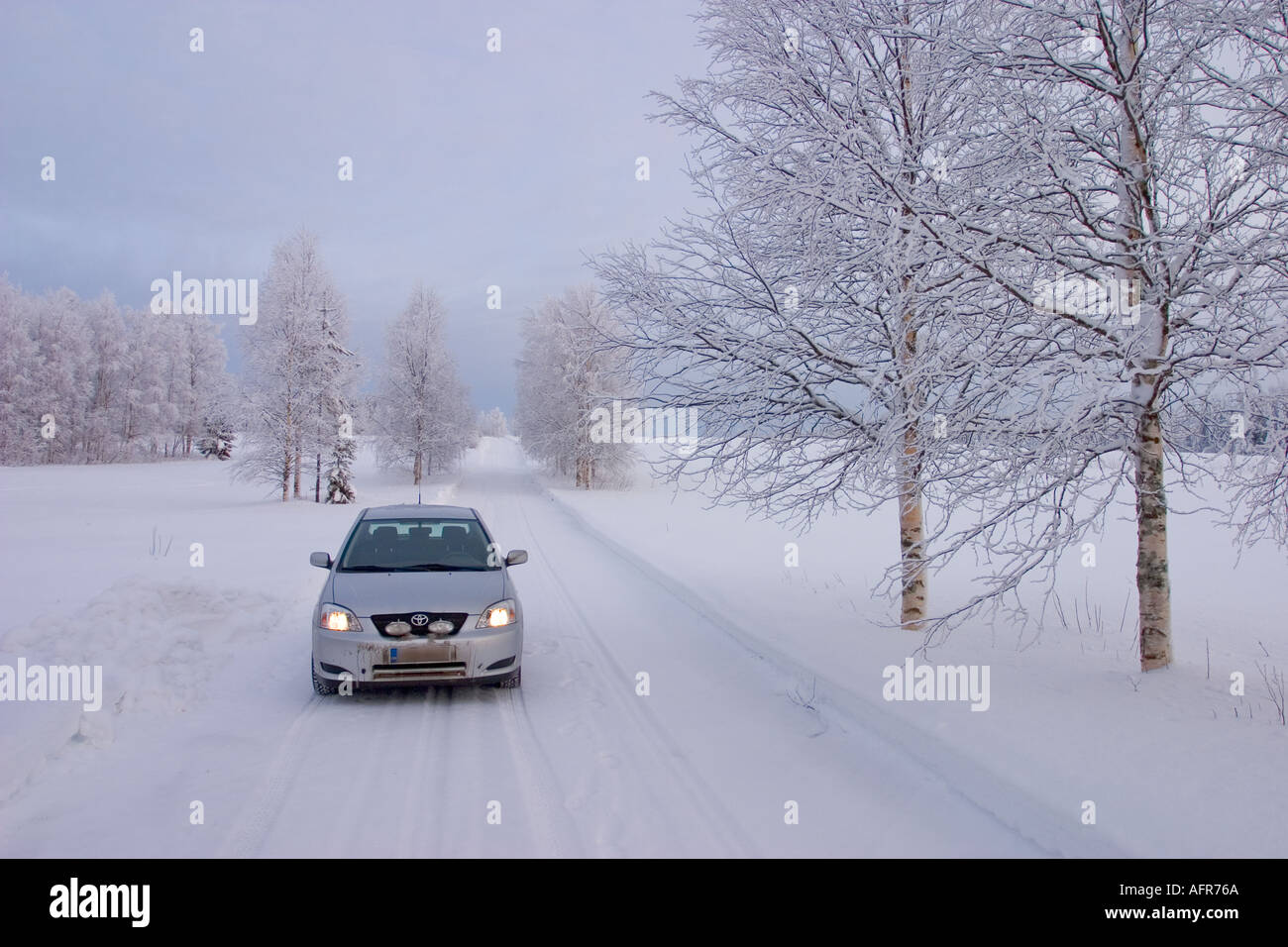 Toyota Corolla sur route de campagne enneigée à Winter, Finlande Banque D'Images