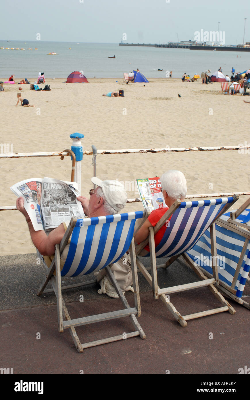 Couple de personnes âgées la lecture dans des chaises longues sur la plage  Photo Stock - Alamy