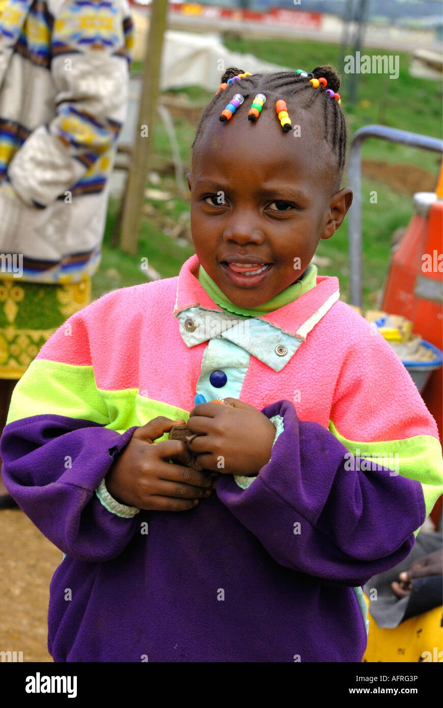 Une jolie jeune fille en robe de Kikuyu moderne avec des billes en plastique de couleur dans ses cheveux le Kenya Afrique de l'Est Banque D'Images