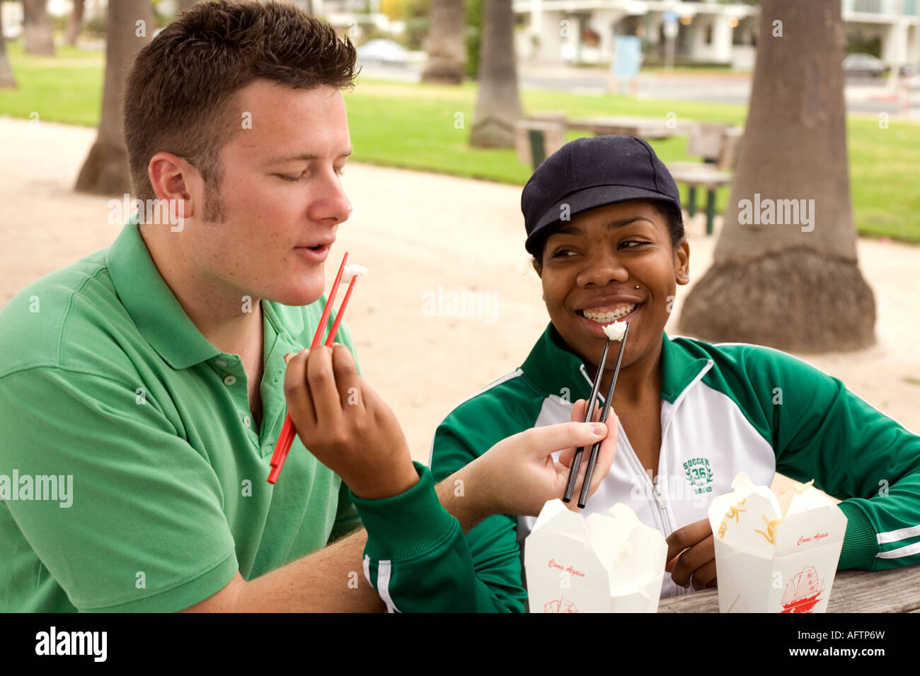 Jeune couple se nourrir les uns les autres au café Banque D'Images