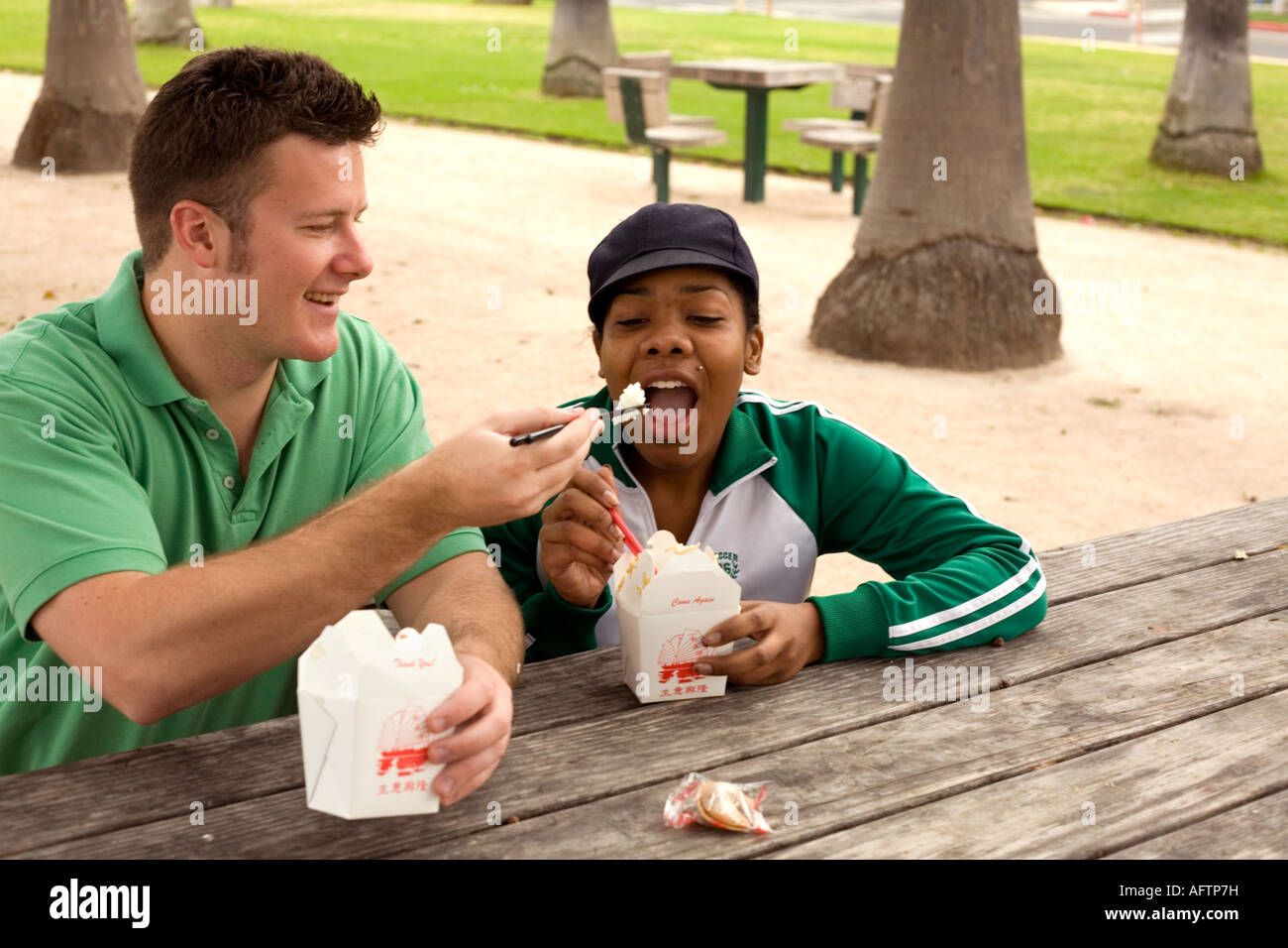 Jeune couple se nourrir les uns les autres au café Banque D'Images