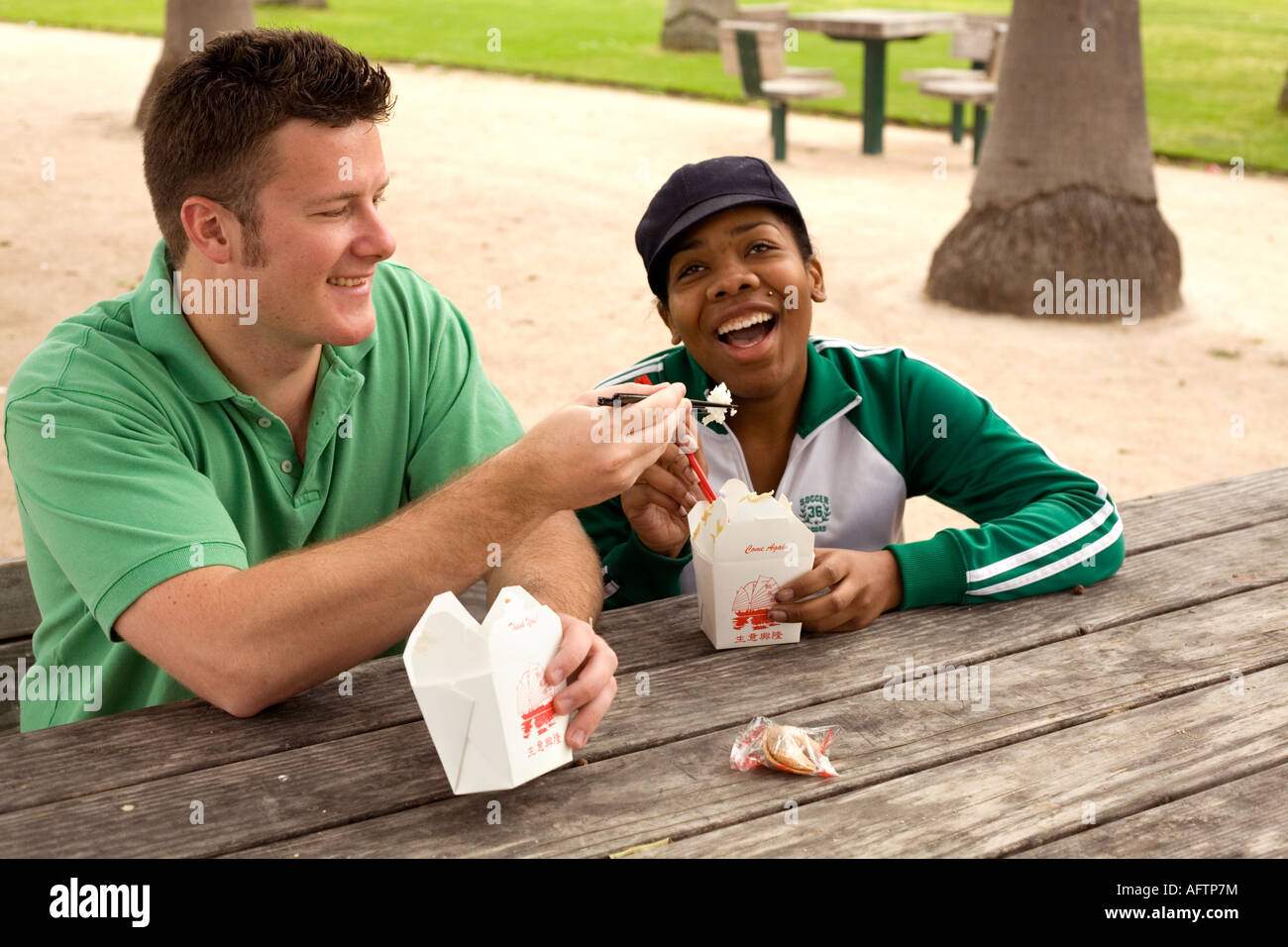 Jeune couple se nourrir les uns les autres au café Banque D'Images