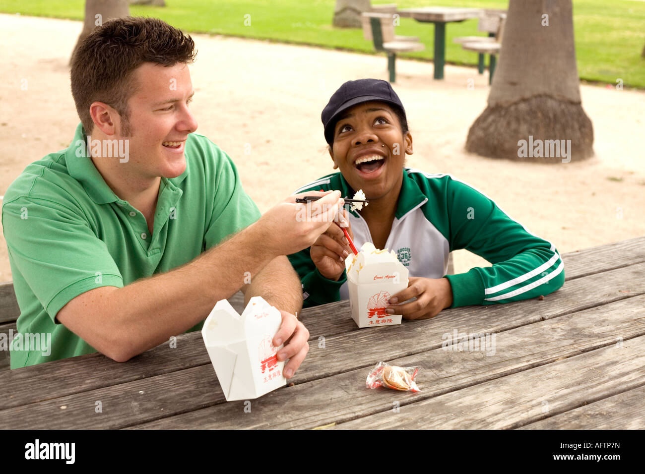 Jeune couple se nourrir les uns les autres au café Banque D'Images