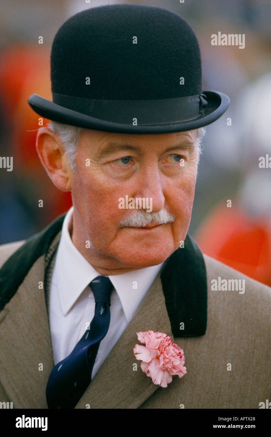 Anglais gent, élégant homme senior chapeau melon rose oeillet dans le trou de bouton le Grand National Horse Race Lancashire 1980s UK 1986 Angleterre HOMER SYKES Banque D'Images