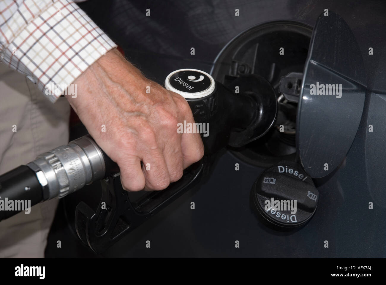 Un homme remplit sa voiture avec du carburant diesel en Angleterre Banque D'Images