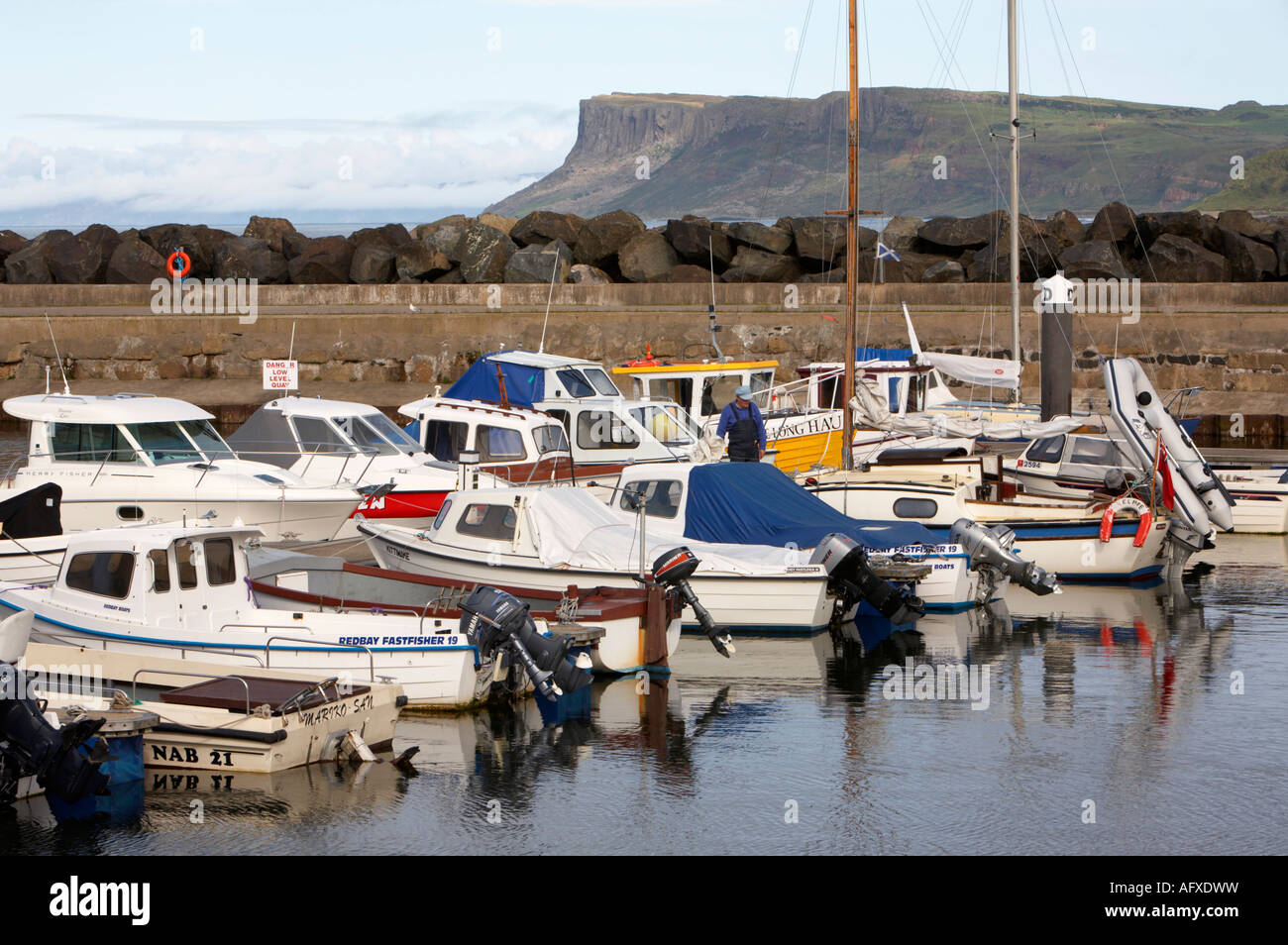 Gamme de petits bateaux de pêche et bateaux de plaisance amarrés dans la marina de Ballycastle avec juste la tête dans l'arrière-plan Banque D'Images