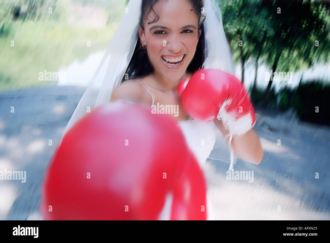 Laughing young bride faisant semblant de se battre avec des gants de boxe Banque D'Images