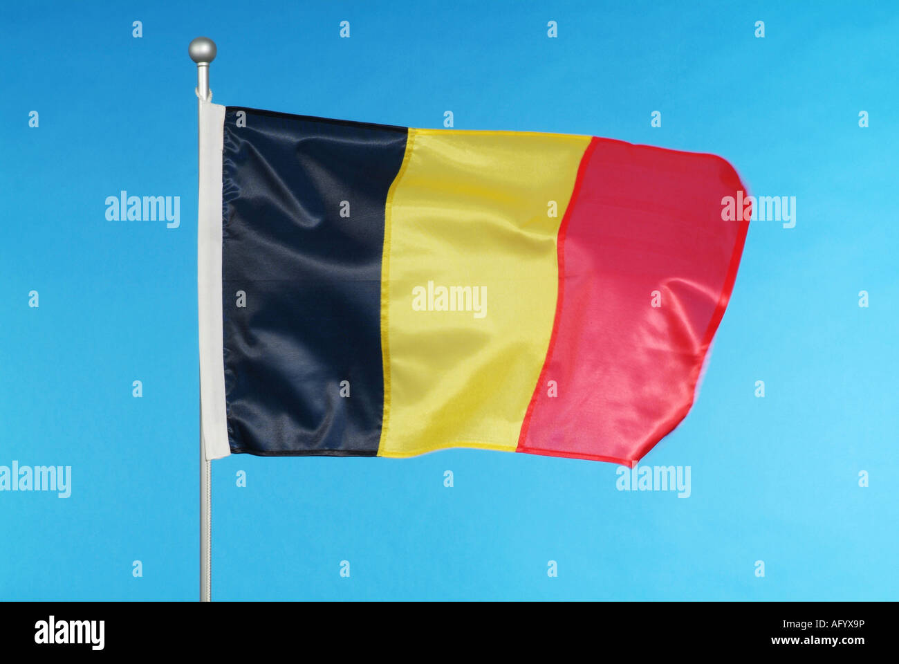 Drapeau national belge contre le ciel bleu Banque D'Images