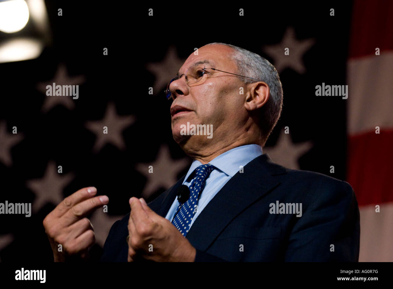 Colin Powell parle devant la toile de fond d'un drapeau américain. Banque D'Images