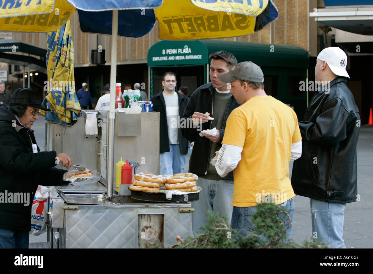 Moyen-orientale vendeur de rue vendant des hot-dogs aux hommes blancs à l'extérieur arrière de Madison square garden 34e rue Banque D'Images