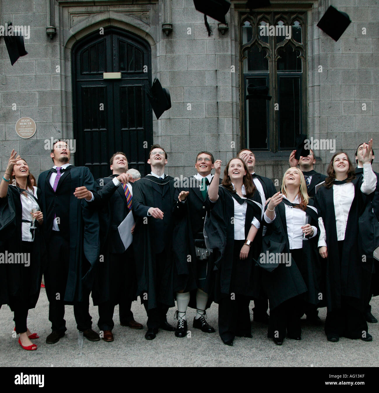 Des étudiants diplômés en jetant de toges conseils mortier dans l'air après avoir obtenu son diplôme à l'Université cérémonie Aberdeen, Scotland Banque D'Images