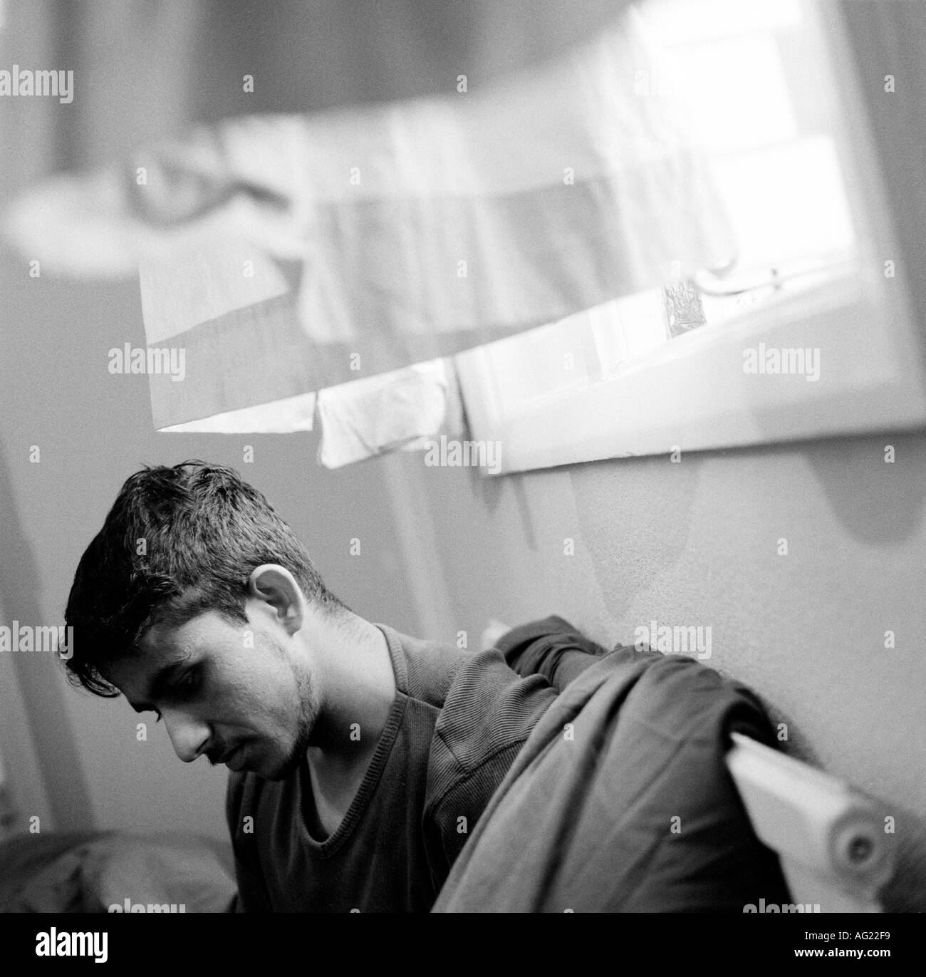 Un jeune demandeur d'asile d'Afghanistan dans sa chambre à l'auberge. Banque D'Images
