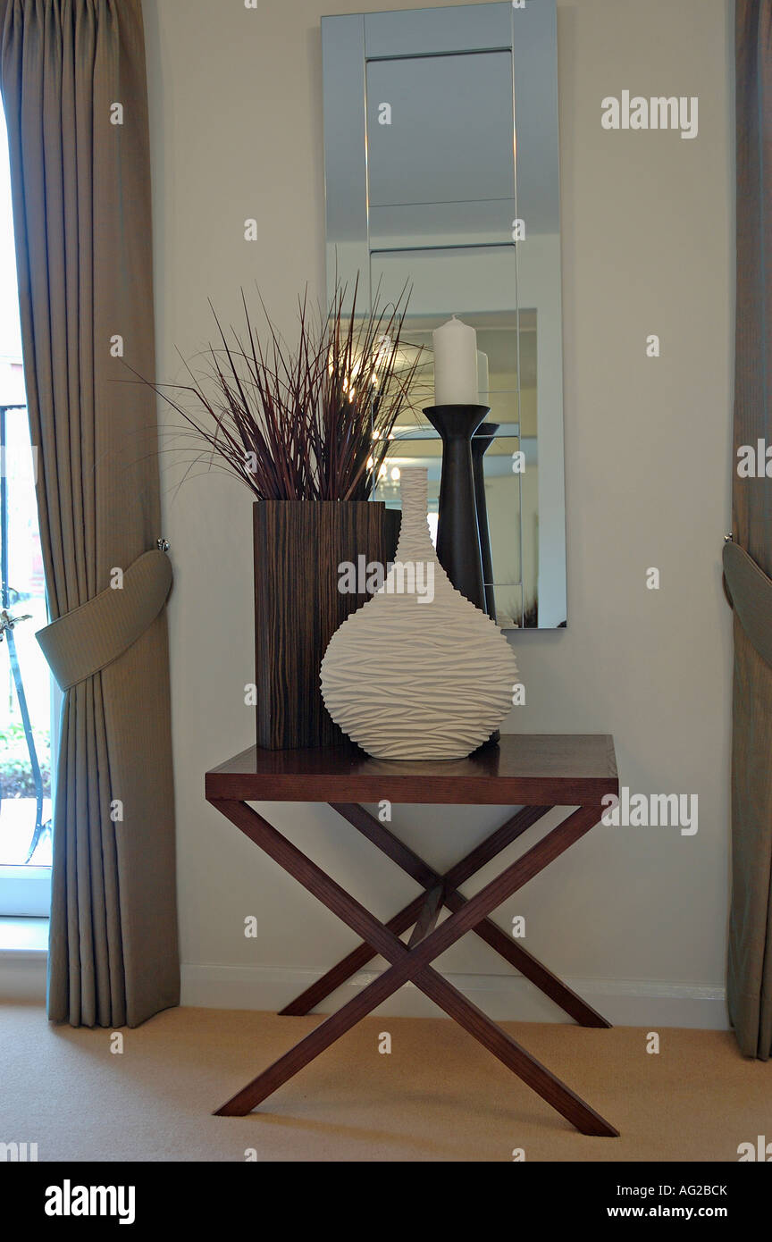 Crème de texture vase et de hauteur avec des branches chandelier vase cylindrique brun en bois moderne sur table en face du miroir en hall Banque D'Images