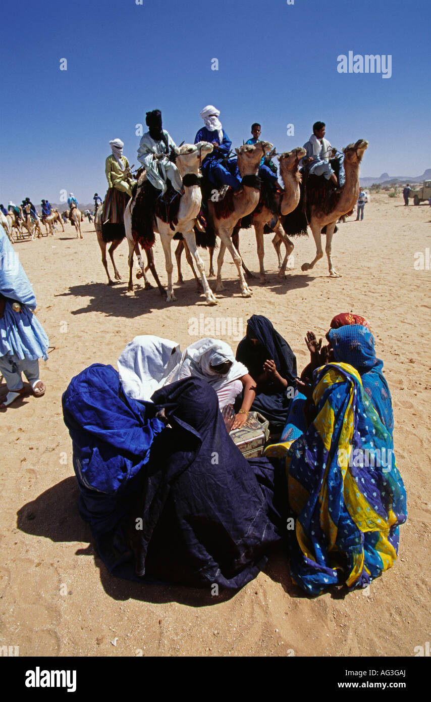 L'Algérie Tamanrasset Personnes de tribu touareg chameau circonscription hommes tandis que les femmes assis sur le sable au cours festival appelé Tafsit Banque D'Images