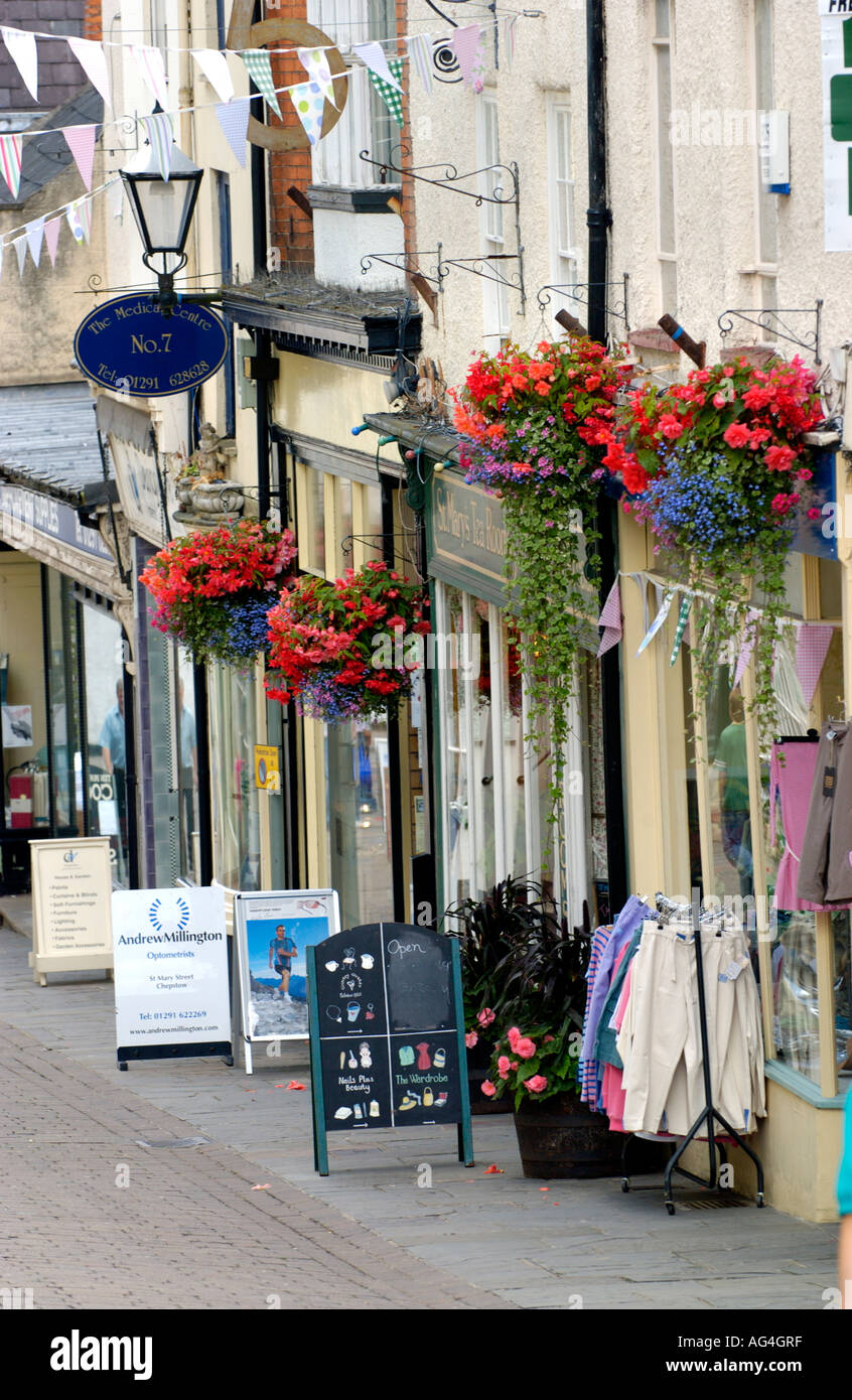 Boutiques de paniers de fleurs suspendus à l'extérieur sur la principale rue commerçante de Monmouthshire Chepstow South East Wales UK Banque D'Images