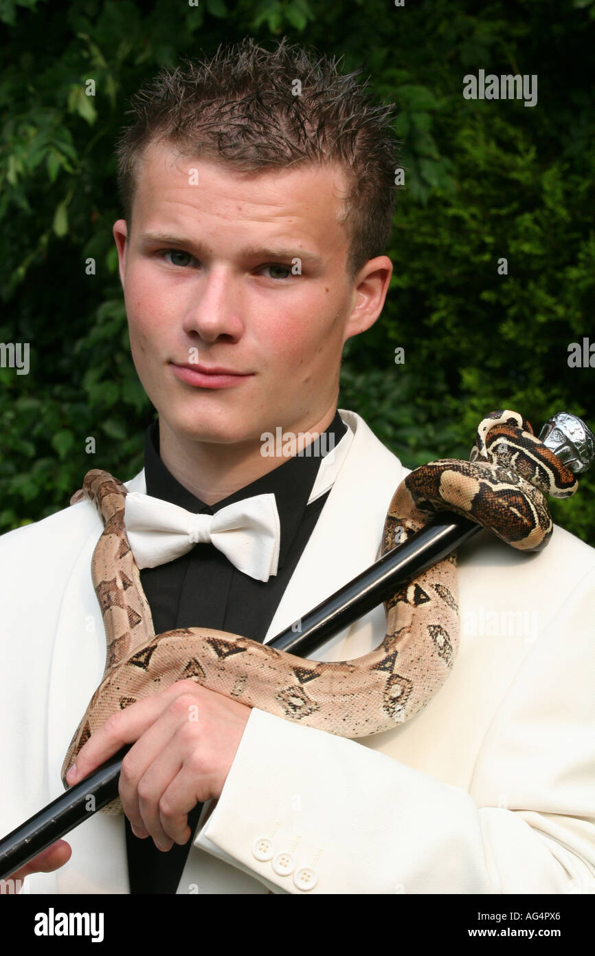 '16 ans Josh à sa partie proms pose avec son animal de compagnie Contricter Boa vêtu d'un costume dîner Banque D'Images