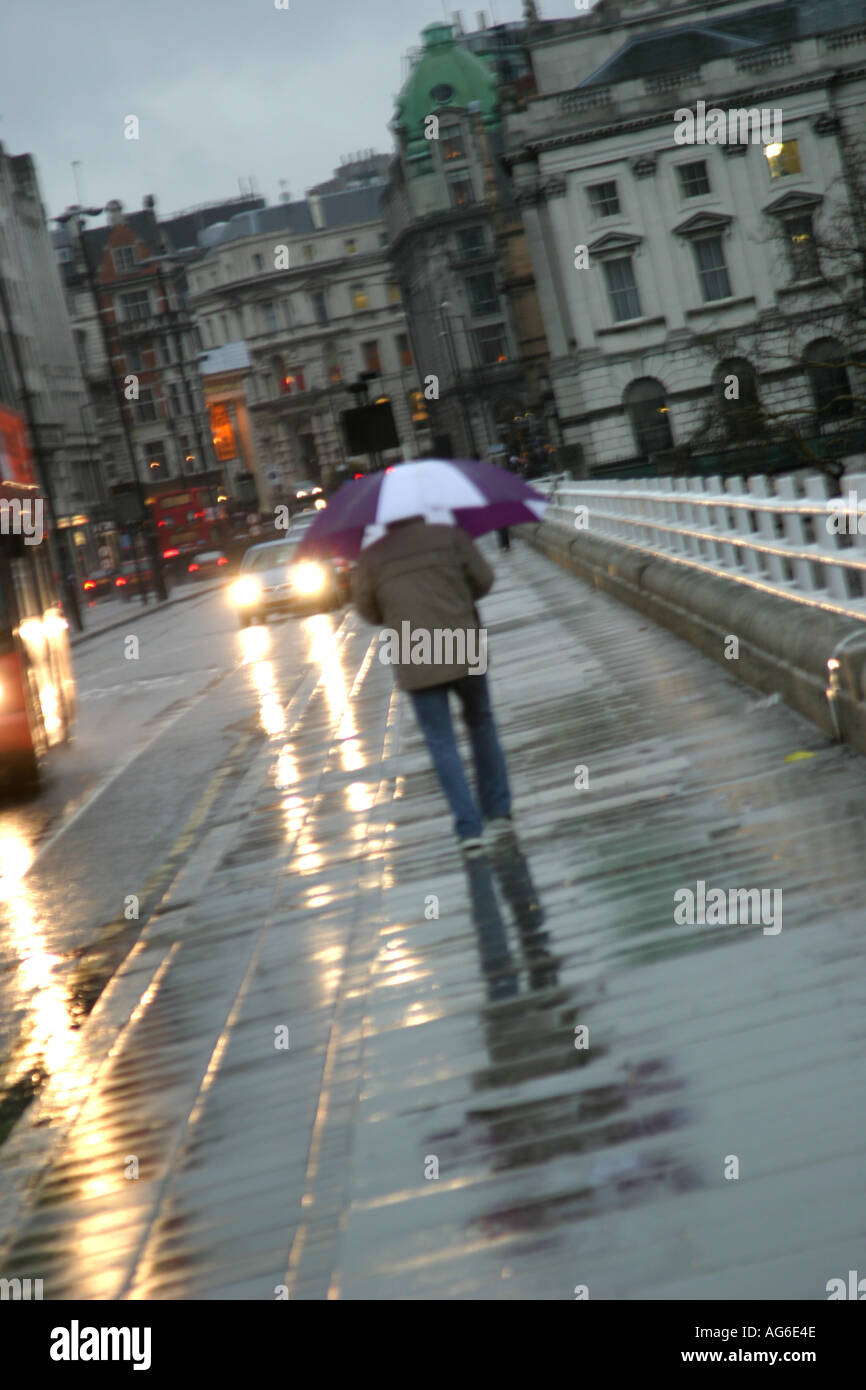 Seule personne marcher sur Waterloo Bridge à Londres sous la pluie Banque D'Images