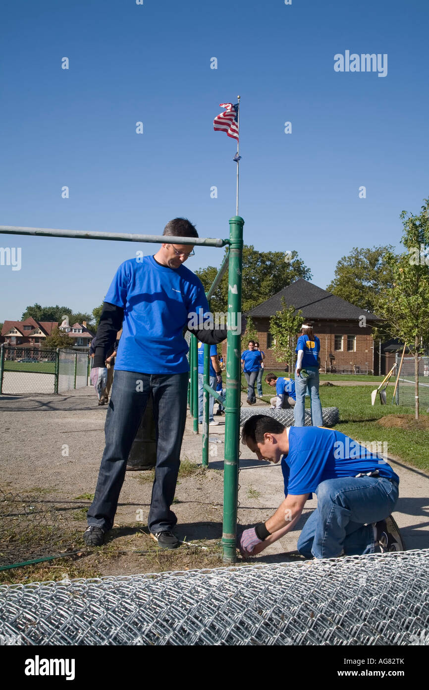 Remplacer les bénévoles clôtures métalliques à un terrain de softball Banque D'Images