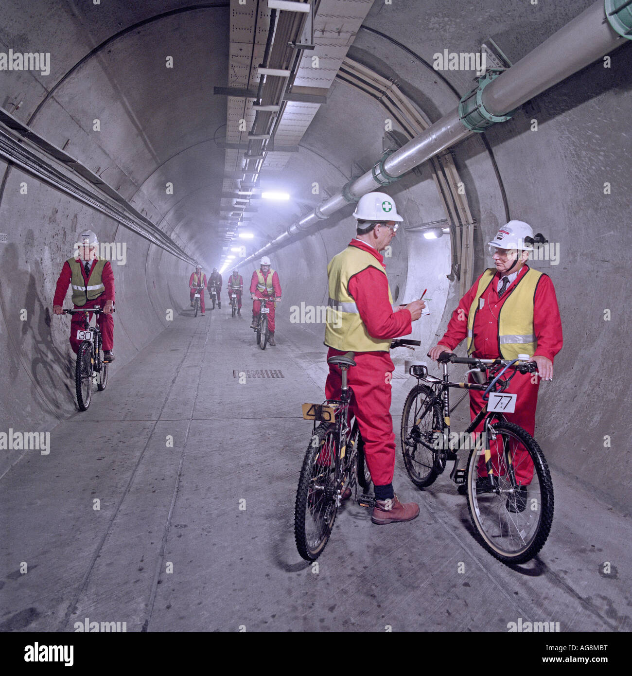 Les ingénieurs d'Eurotunnel en utilisant des bicyclettes pour couvrir de nombreux kilomètres chaque jour suivi de la qualité du travail en cours sur le Tunnel sous la Manche. Banque D'Images