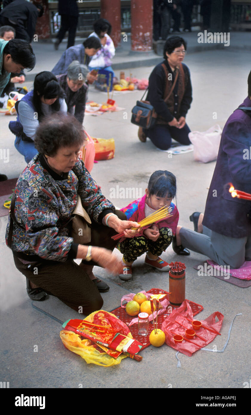 La Chine, Hong Kong, femme et enfant offert dans le Temple de Wong Tai Sin Banque D'Images