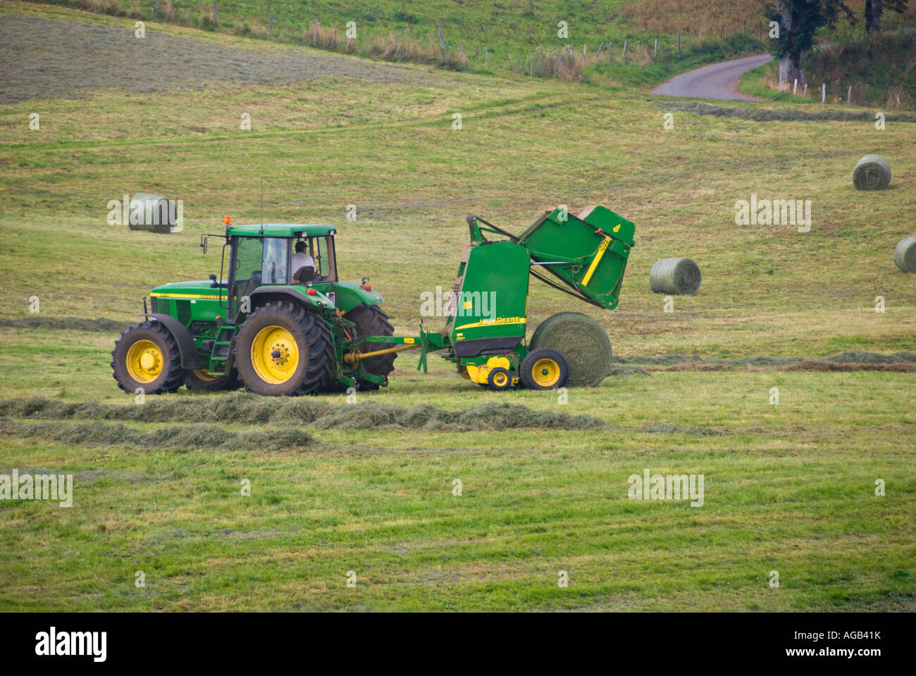 L'Auvergne. La récolte du foin. Presse à balles rondes en action. Banque D'Images