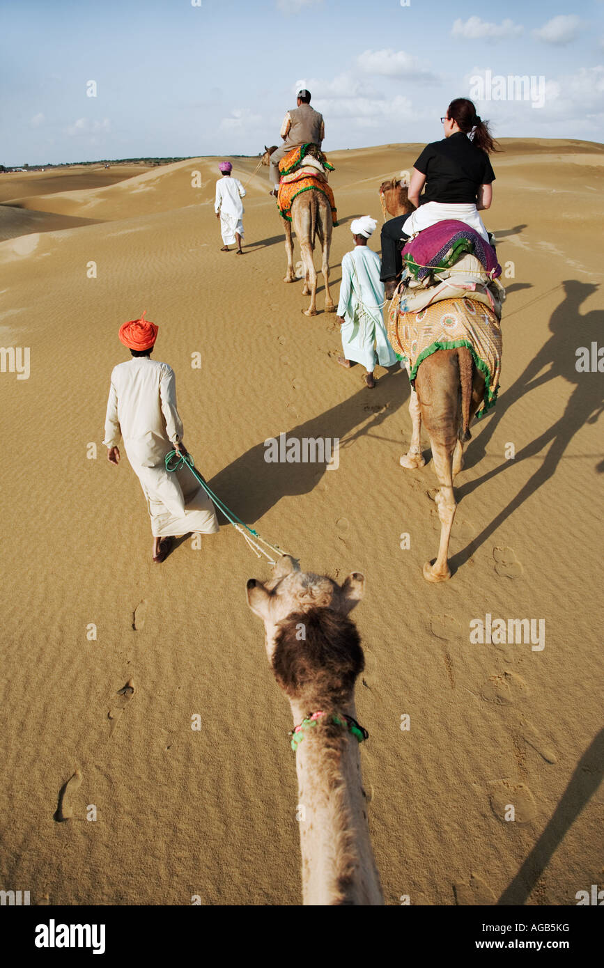 Les touristes sur un safari de chameau dans le grand désert du Thar à l'extérieur de l'Inde Jaisalmer Banque D'Images