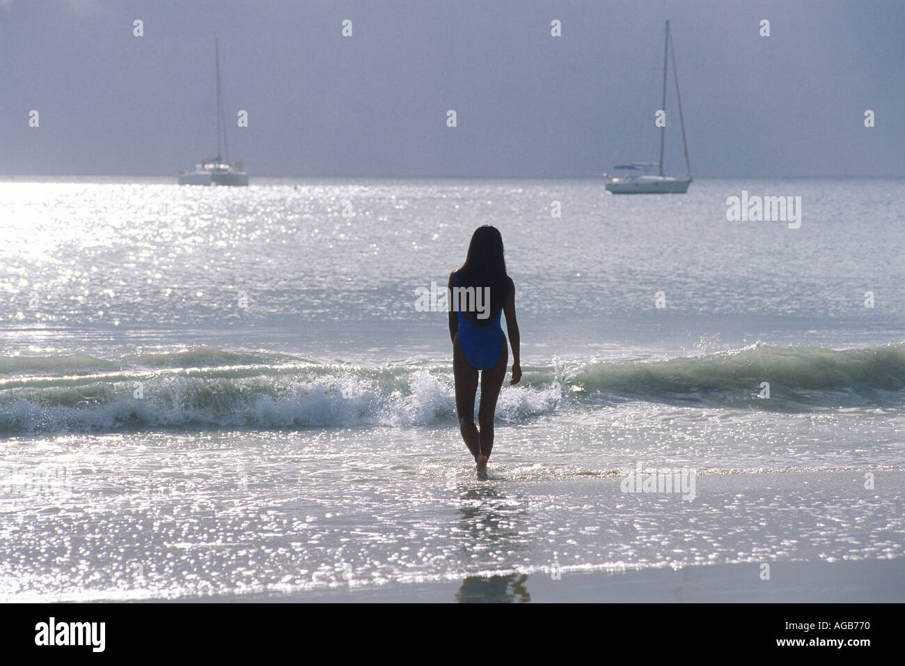 Silhouette Femme à terre avec des vagues et voiliers Banque D'Images