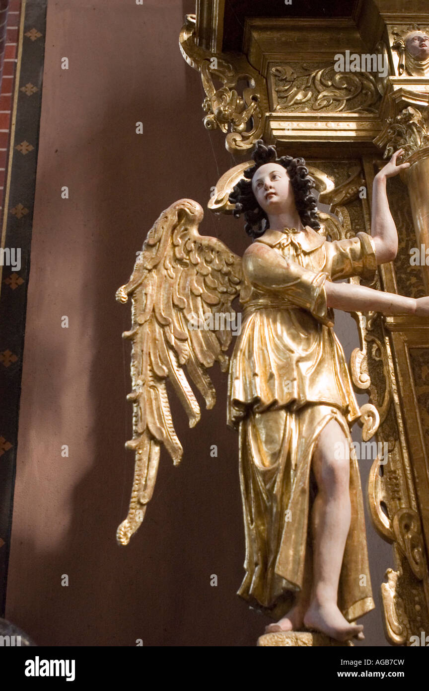 Statue d'ange baroque doré dans la cathédrale de Frombork, Pologne. Sculpture complexe de feuilles d'or avec ailes détaillées et robes coulantes dans une église historique. Banque D'Images