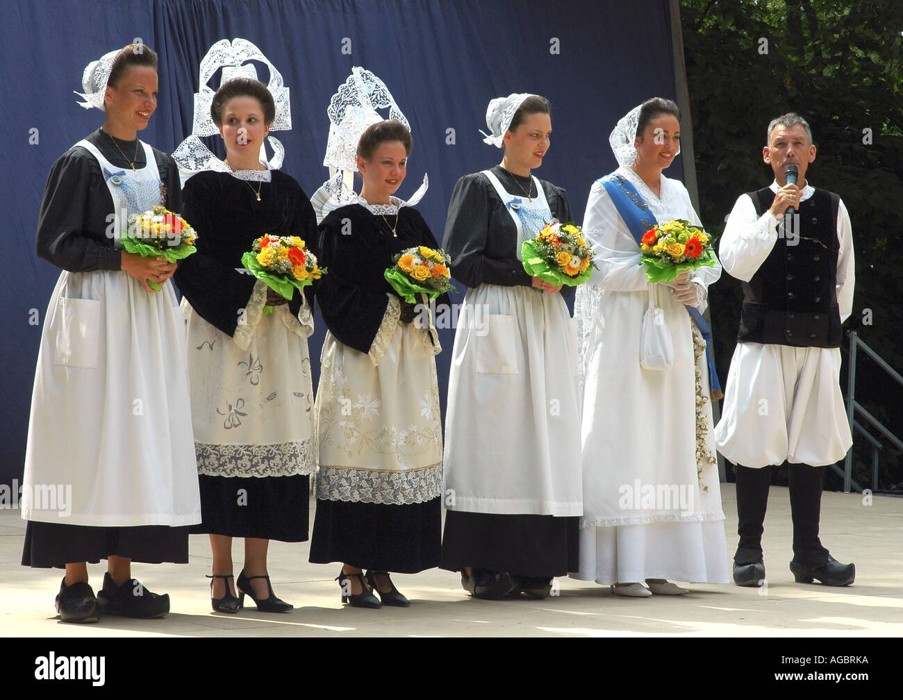 Cinq jeunes femmes en costumes Breton classique sont introduites à un festival de folklore d'été dans le Breton Cornwall Banque D'Images