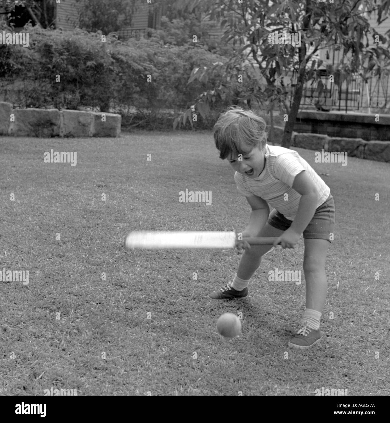 Jeune garçon à jouer au cricket dans le jardin Banque D'Images