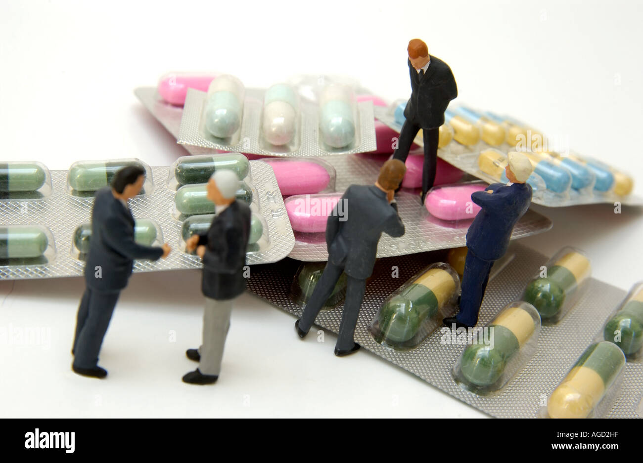 Les figurines miniatures s'engagent dans la conversation autour de capsules et de comprimés aux couleurs vives, présentant une perspective unique sur le monde pharmaceutique Banque D'Images