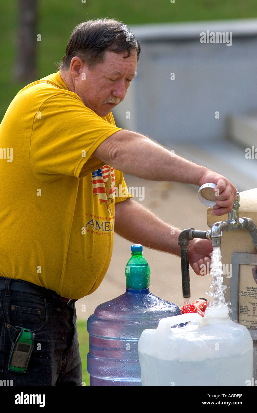 Un homme d'eau de remplissage de bidons d'une fontaine d'eau publique de Hot Springs, Arkansas. Banque D'Images