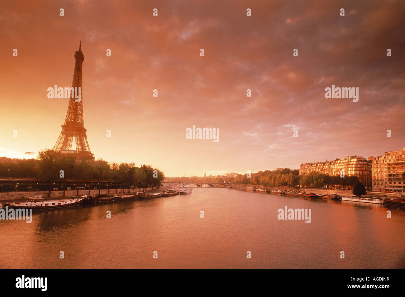 La Tour Eiffel au-dessus des toits de Paris appartements, le long de la Seine au lever du soleil Banque D'Images
