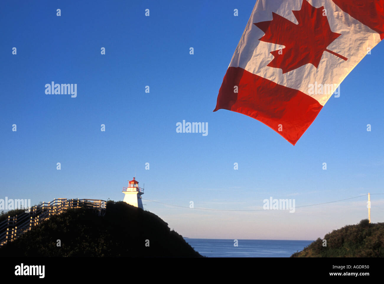 Drapeau canadien survolant phare du cap Enragé Nouveau-Brunswick Canada Banque D'Images