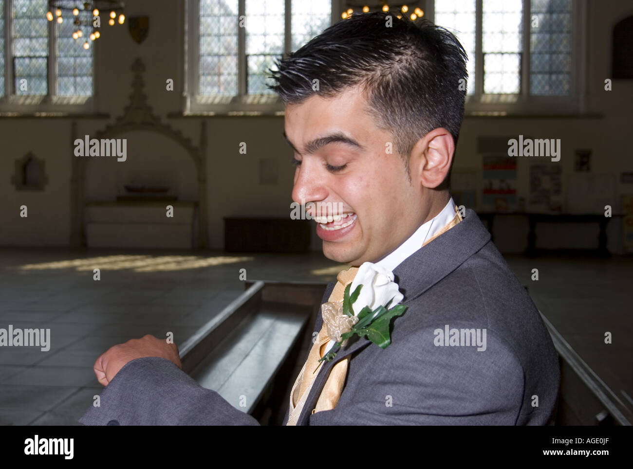 Marié kurde vérifie son regardez comme il attend dans l'église anglaise pour l'arrivée de la mariée Banque D'Images