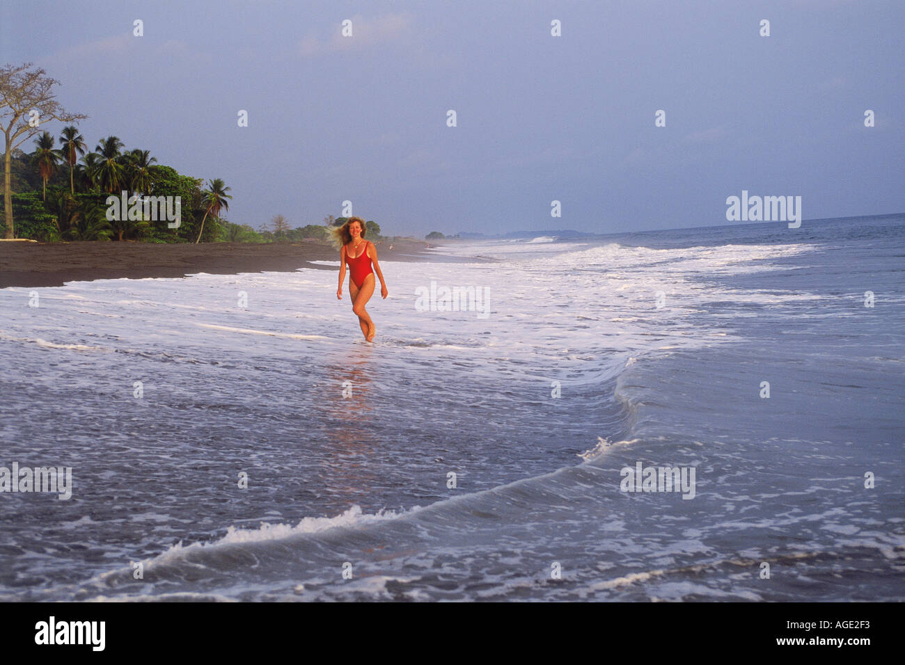 Femme sur plage de lave noire à Playa Hermosa au Costa Rica Banque D'Images