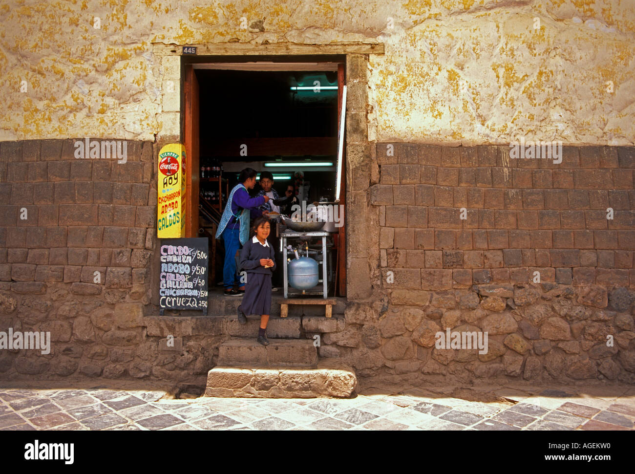 Woman cooking, lycéenne, eatery, restaurant, pierres Incas à la base du mur, Calle Pampa del Castillo, Cusco, Cuzco, Pérou, Province de l'Amérique du Sud Banque D'Images